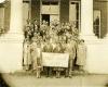 A group of people st和 together in an archived 1926 photo